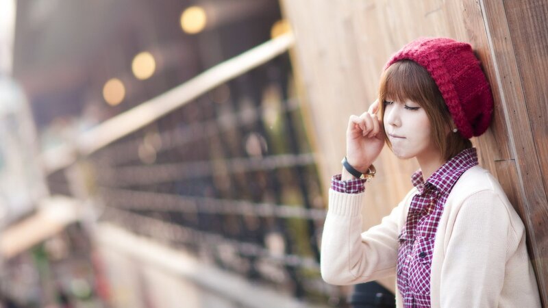woman in red hat leaning on wall