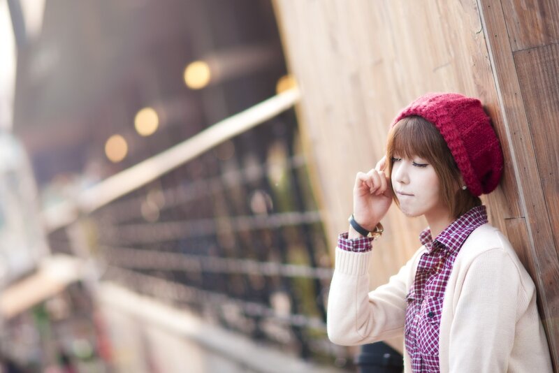 woman in red hat leaning on wall