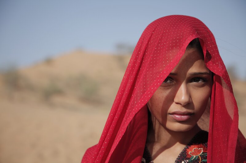 woman in red headscarf in desert