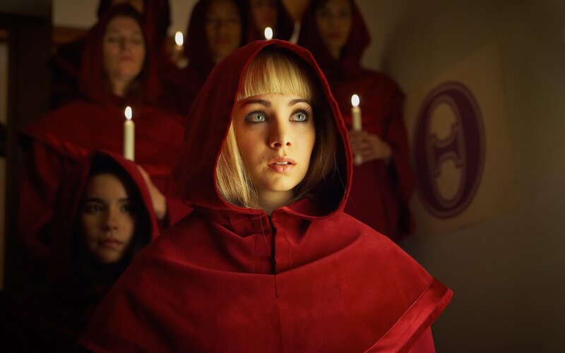 woman in red hood with candlelight