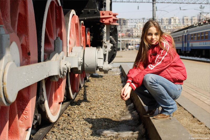 Woman in red jacket by train
