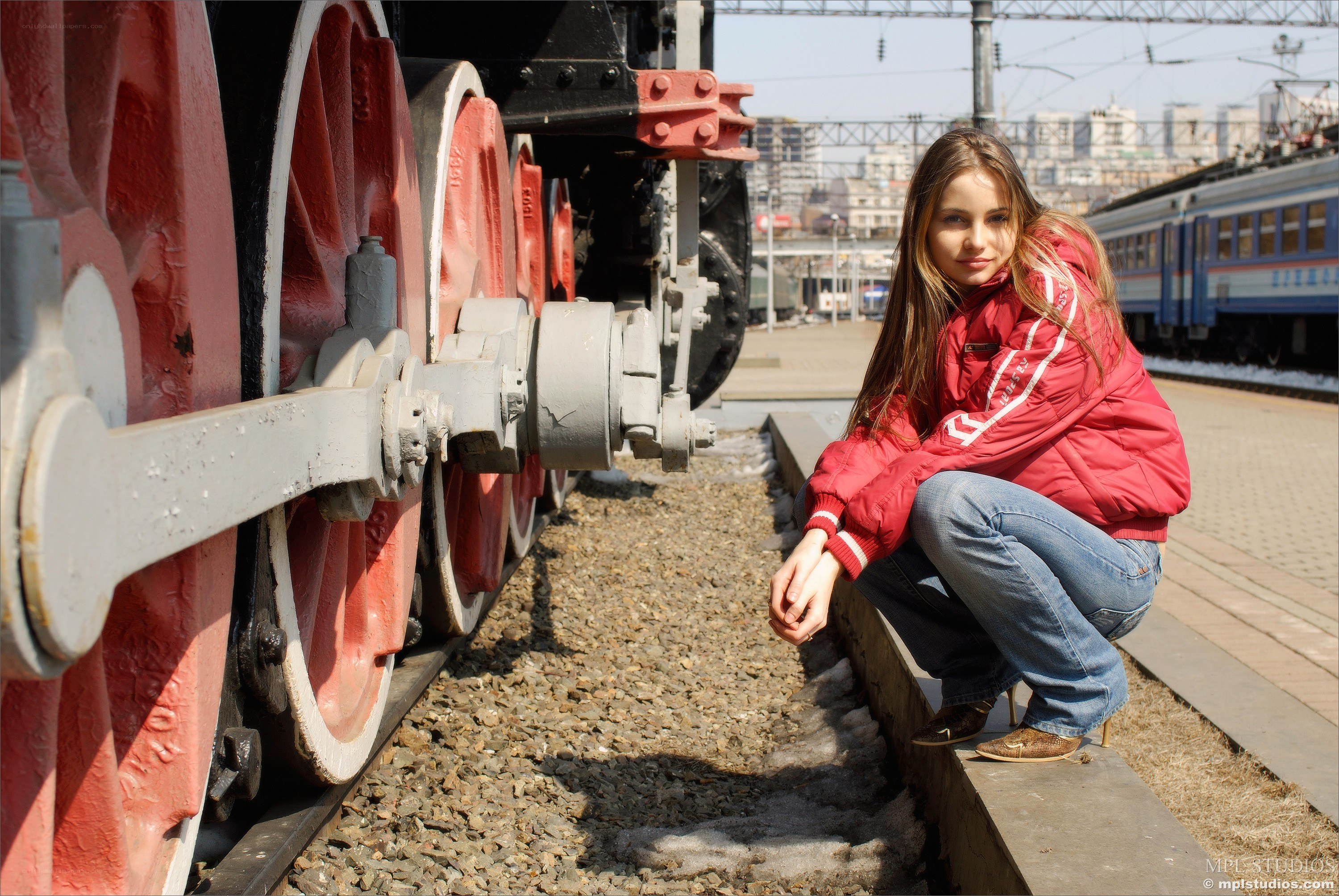Woman in red jacket by train