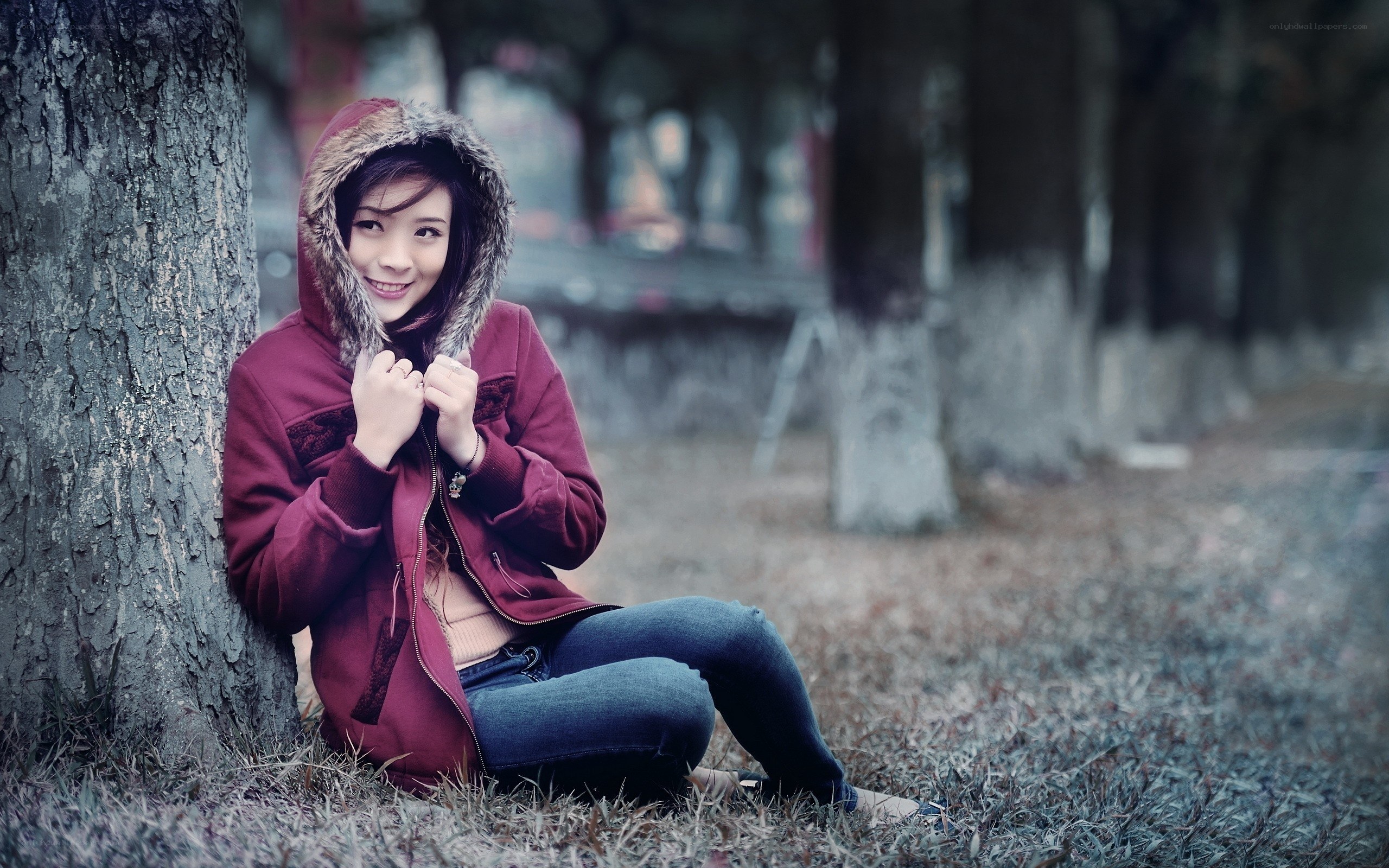 Woman in red jacket by tree