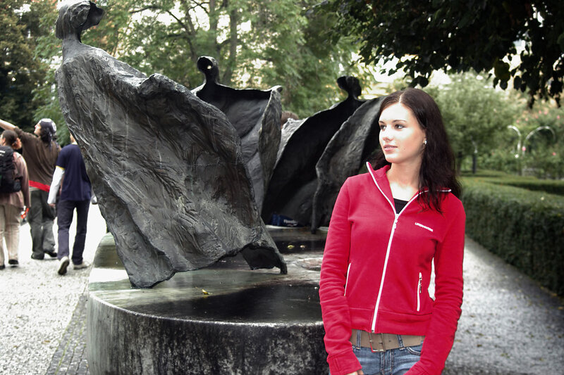 Woman in red jacket near sculpture