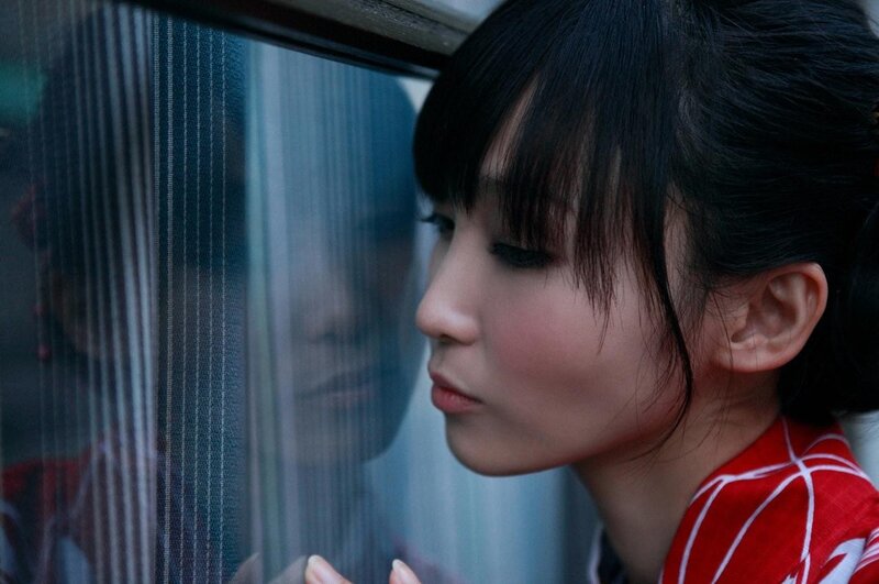 woman in red kimono by window