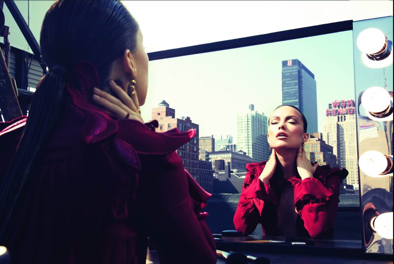 woman in red looking at mirror