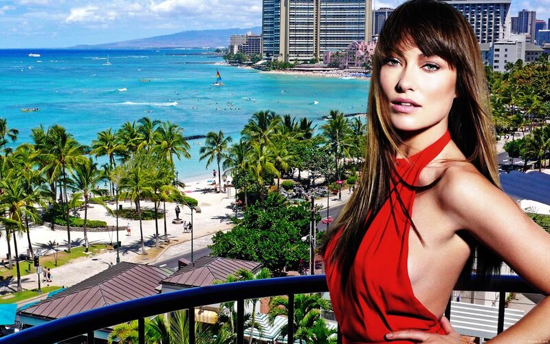 woman in red on balcony overlooking beach