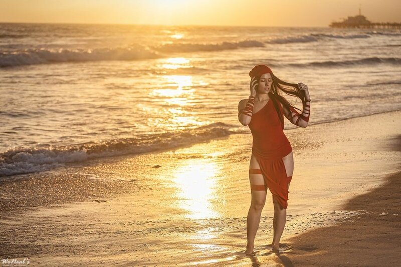 Woman in red on beach at sunset