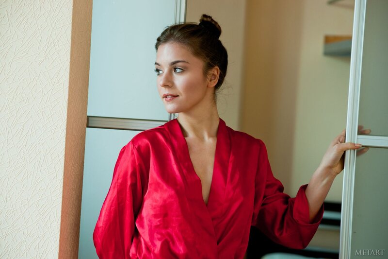 woman in red robe by window