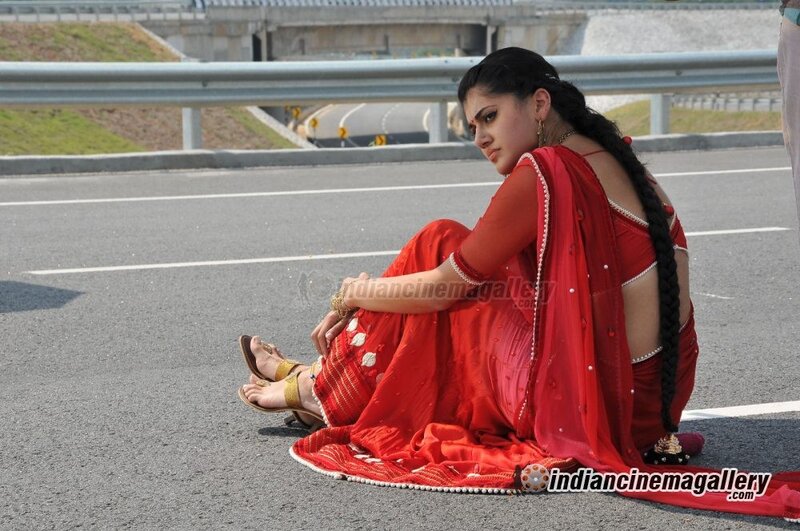 woman in red sari sitting on road