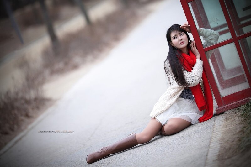 woman in red scarf sitting on pavement