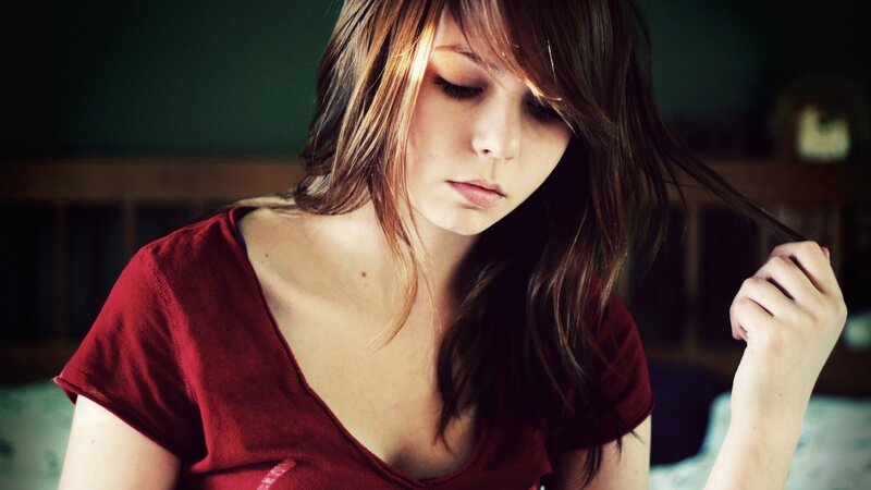 woman in red shirt looking down