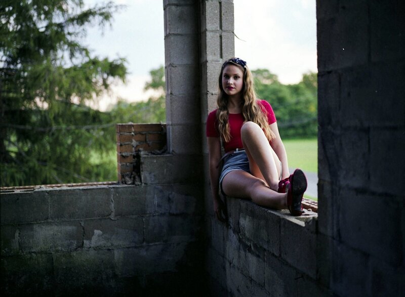 woman in red shirt sitting on wall