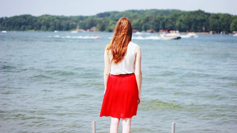 Woman in red skirt by the lake