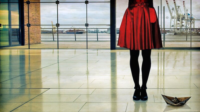 woman in red skirt by window