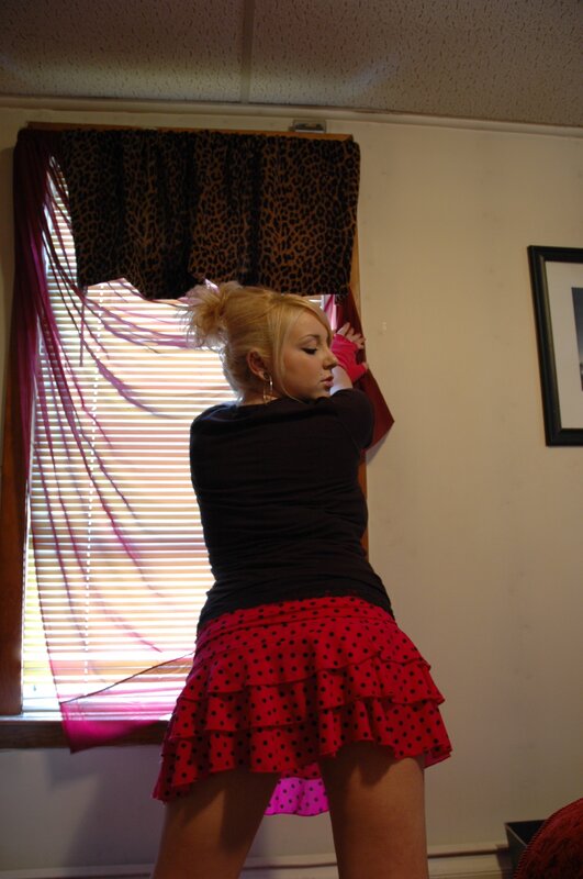 woman in red skirt by window