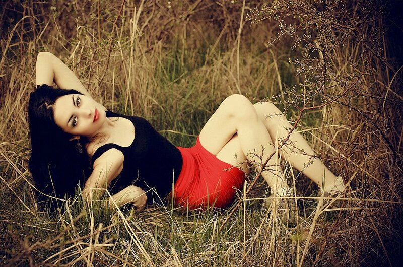 woman in red skirt lying in grass