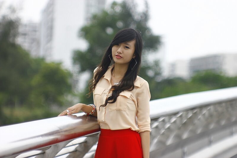 woman in red skirt on bridge