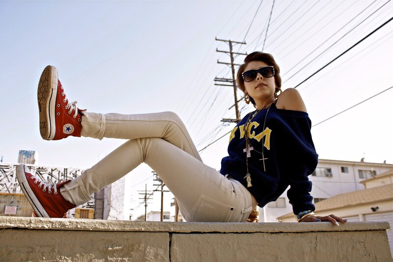woman in red sneakers sitting on wall