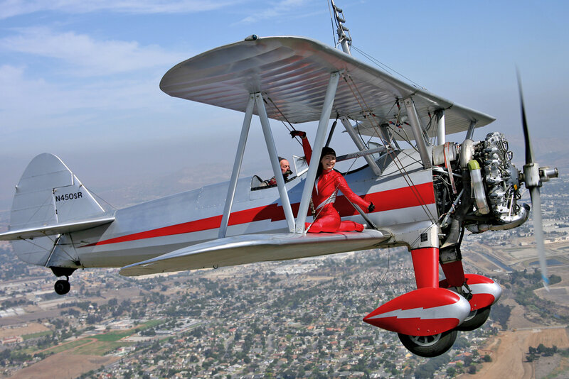 Woman in Red Suit on Biplane