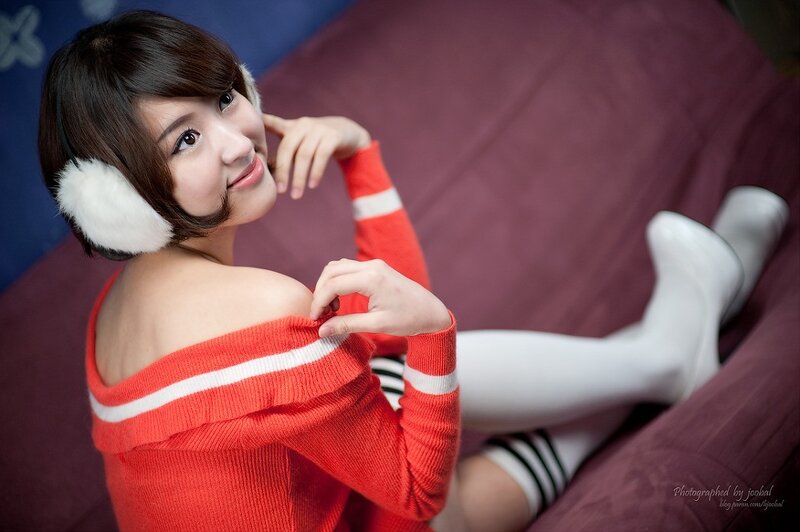 woman in red sweater and earmuffs
