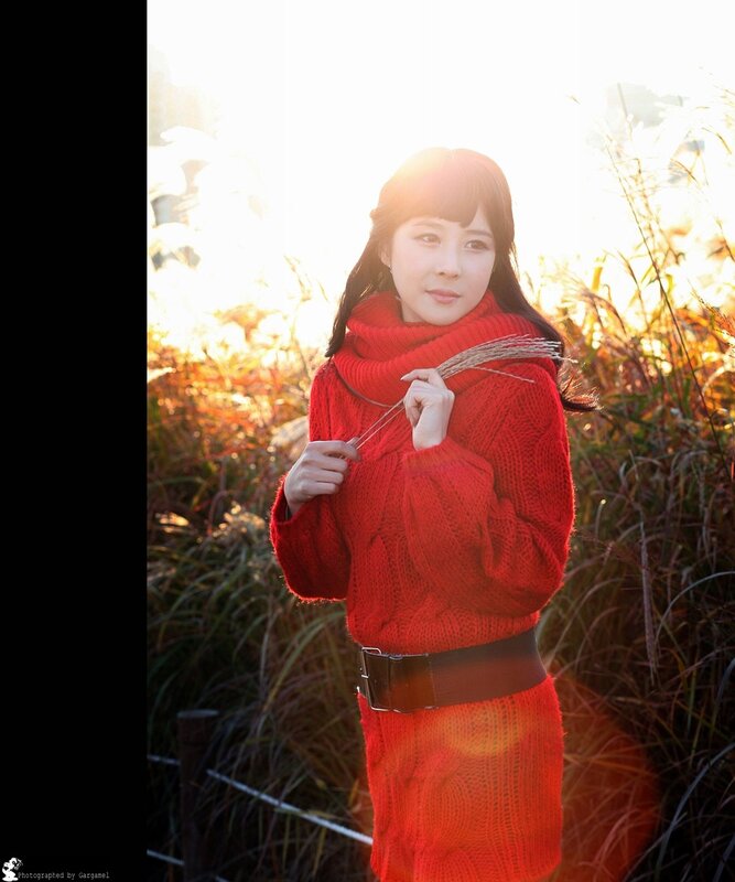 Woman in red sweater at sunset