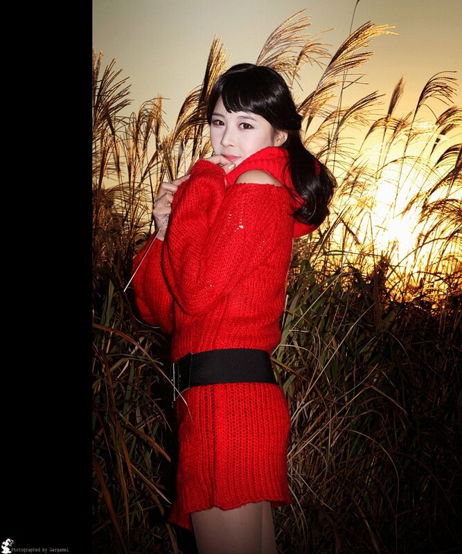 Woman in red sweater at sunset