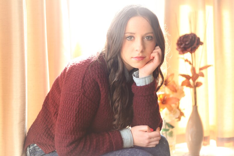 woman in red sweater by window