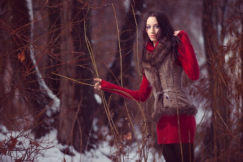 Woman in red sweater in winter forest