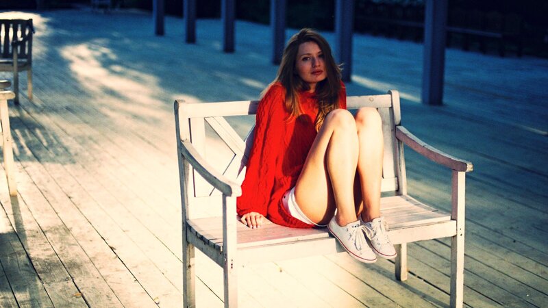 Woman in red sweater on bench