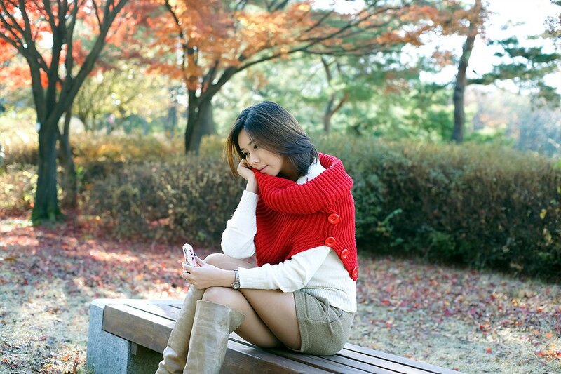 Woman in red sweater on bench