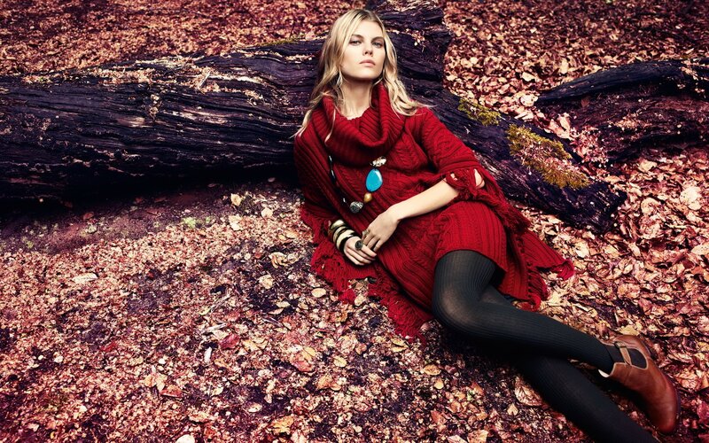 Woman in red sweater on forest floor
