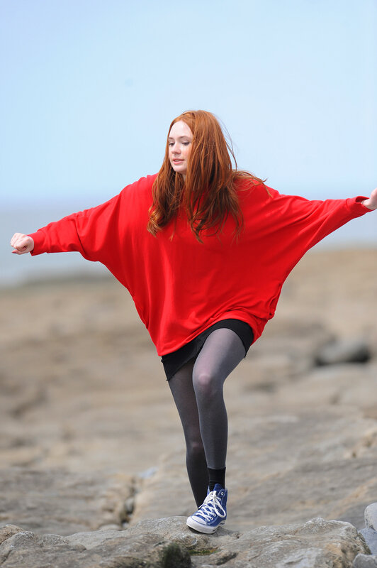 Woman in red sweater on rocks