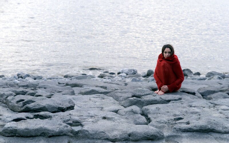 woman in red sweater on rocks