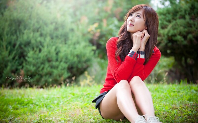 woman in red sweater sitting on grass