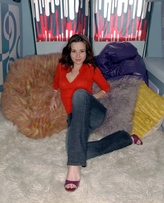 Woman in red sweater sitting on rug