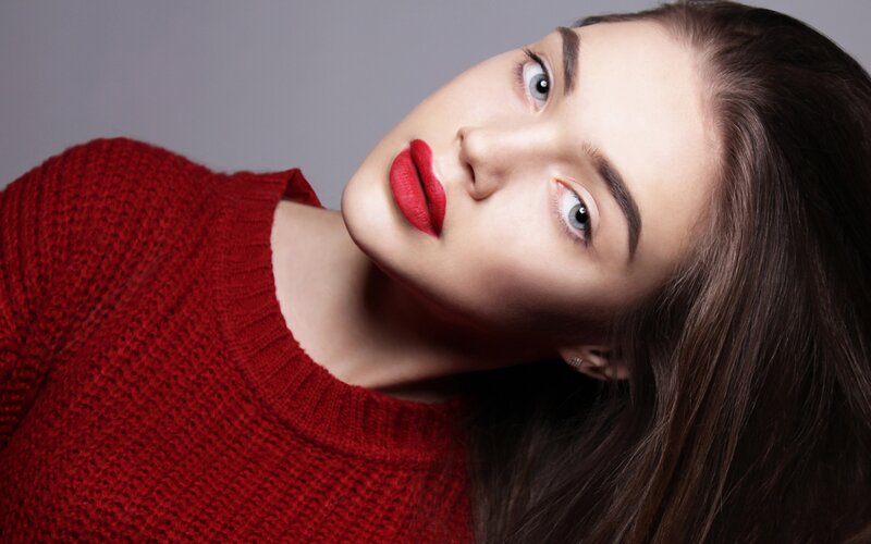 woman in red sweater with bold lipstick