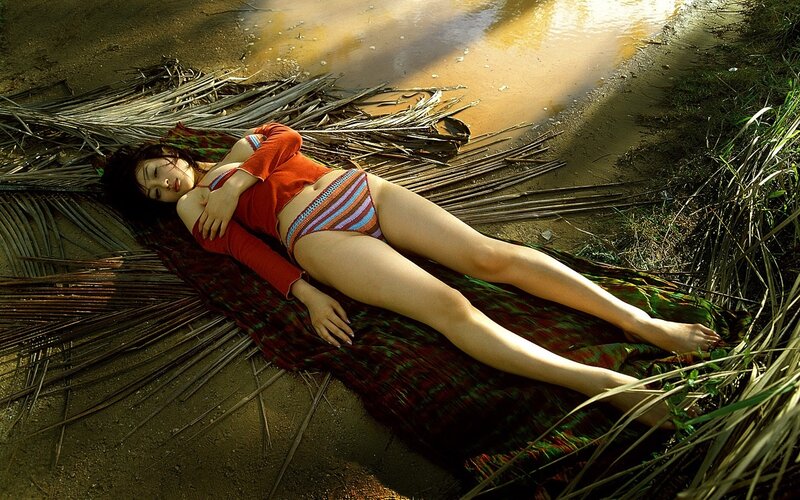 Woman in red swimsuit lying on mat
