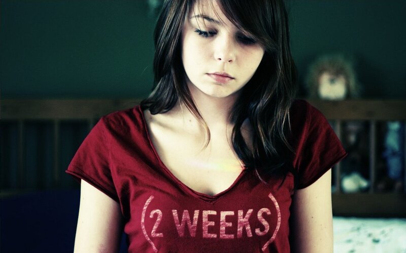 woman in red t-shirt looking down