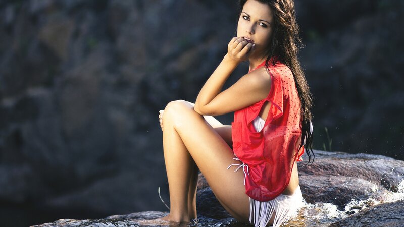 woman in red top by water