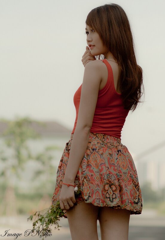 woman in red top holding flowers