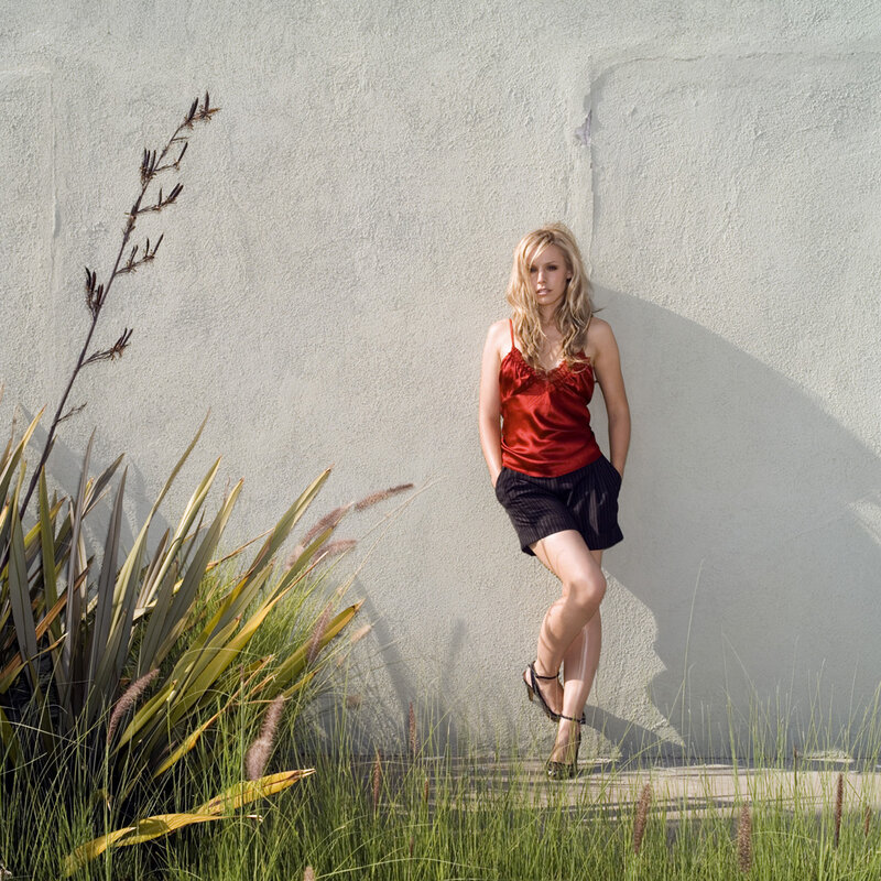 woman in red top leaning on wall