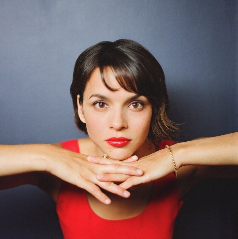 woman in red top with hands clasped