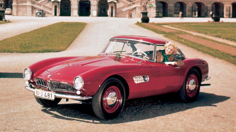 Woman in red vintage car
