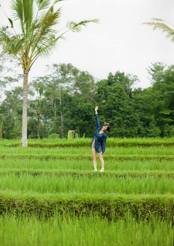 Woman in rice field waving