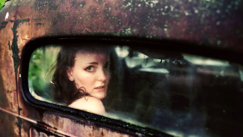 woman in rusted car mirror