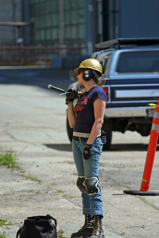 Woman in safety gear with tool
