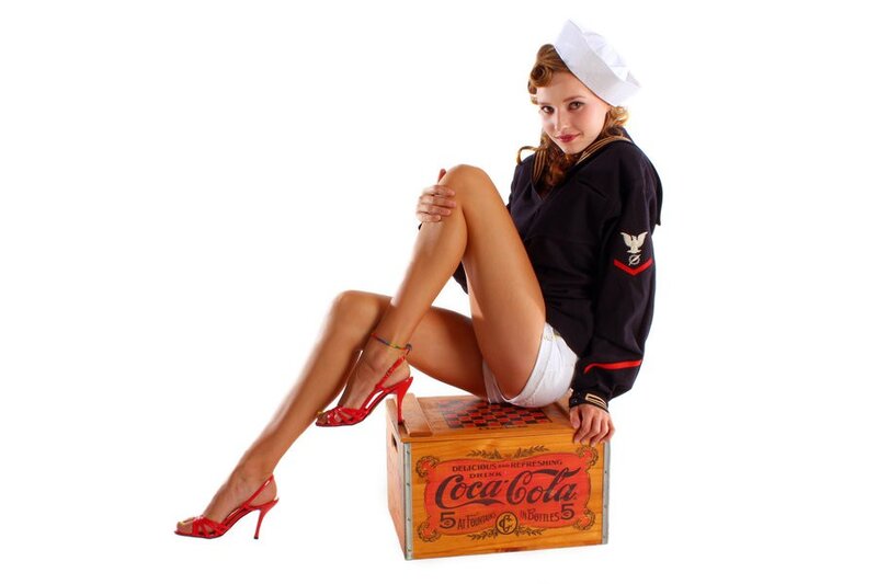 woman in sailor outfit sitting on coca-cola crate