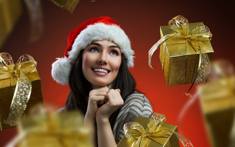 woman in santa hat with gifts