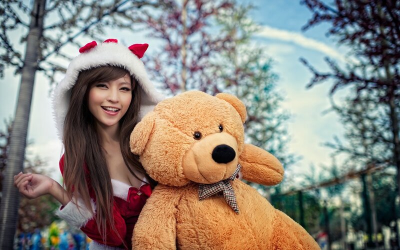 woman in santa outfit with teddy bear